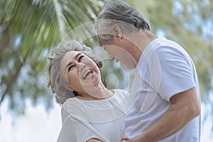 Smile asian senior retired couple, relax smiling elder man and woman enjoying with retired vacation at sea beach outdoor. Health