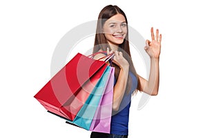 Smile beautiful happy woman holding shopping bags and showing okay sign, isolated on white background