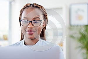 Smile, black woman in office reading on laptop and checking email, online report or business proposal. Glasses, computer