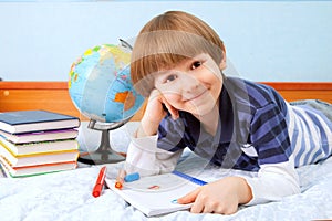 Smile boy with notebook and felt pens