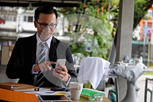 Smile businessman with smartphone in coffee shop