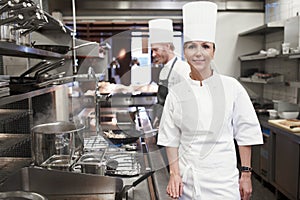 Smile, chef and portrait of woman in kitchen for hospitality service, career and cuisine at restaurant. Fine dining