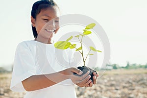 smile children holding young tree for planting