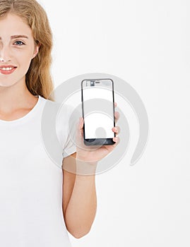 Smile cute girl, woman in tshirt hold blank screen cell phone isolated on white background. Arm holding smartphone, copy space