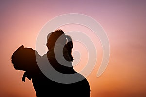 Smile daughter and his father are playing and hugging outdoors.  Silhouette color style