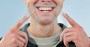 Smile, dental health and a person pointing to mouth for cleaning, Invisalign or braces on a blue background. Medical