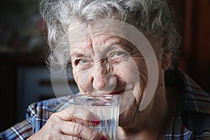 Smile elderly woman drinks water