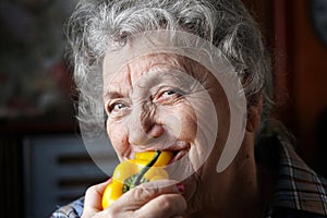 Smile elderly woman eating pepper