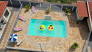 Smile emoji icon floating at swimming pool at countryside