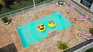 Smile emoji icon floating at swimming pool at countryside