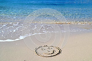 Smile face written in the sand