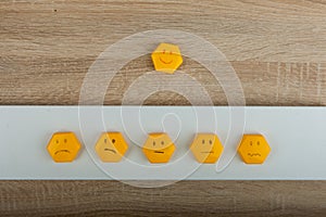 smile-faced group of sad emojis against the background of a wooden table. Be positive.