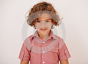 Smile, fashion and boy child in studio with casual, trendy and cool shirt for outfit with curly hair. Happy, cute and