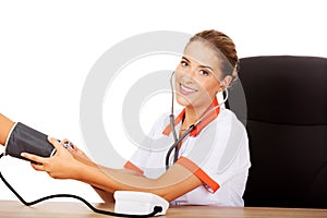 Smile female doctor or nurse checking blood pressure patient