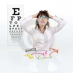 Smile female face chooses spectacles on eyesight test chart