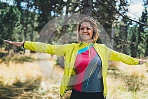 Smile girl exercising outdoors in green park, activity with stretch arms. Young fitness woman doing stretching exercises training