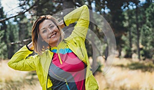 Smile girl exercising outdoors in green park, activity with stretch arms. Young fitness woman doing stretching exercises training