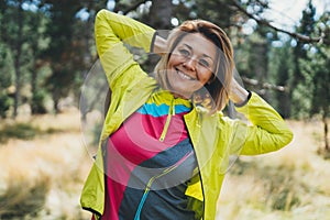 Smile girl exercising outdoors. Relaxing activity with stretch arms. Young fit woman doing stretching exercises training outside