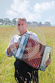 Smile grandfather plays on accordion