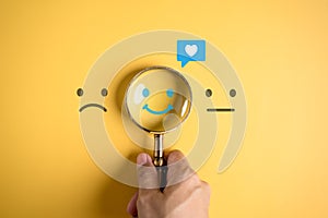 Smile happy face inside of magnifier glass with love icon massge between sad and normal emotion, Positive emotion, Mental health