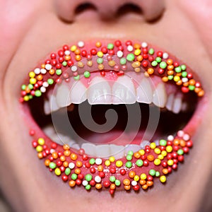 Smile lips. Multicolored delicious mouth. Beautiful lips with small sweets. Dessert and sexy taste. White teeth in
