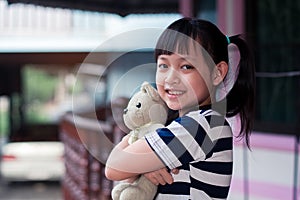 Smile little child girl holding teddy bear with love