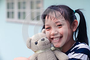 Smile little child girl hugging teddy bear with love