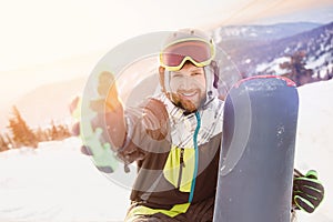 Smile man with snowboard take selfie photo background ski resort sunset. Concept banner winter travel, Sheregesh