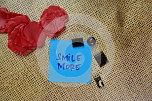 Smile More write on sticky notes isolated on Wooden Table