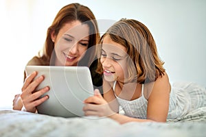 Smile, mother and child on tablet in bed at home together for game, relax and family streaming movie. Happy girl, mom