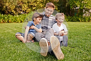 Smile, nature and portrait of kids with father relaxing on grass in outdoor park or garden. Happy, family and excited