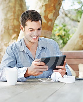 Smile, park and man with tablet in nature on table for networking, email and freelance job. Happy, digital nomad and