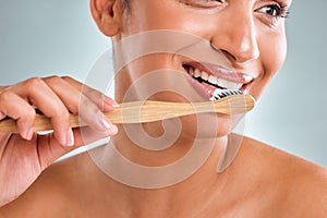 A smile so perfect deserves to be preserved. Studio shot of an attractive young woman brushing her teeth against a grey