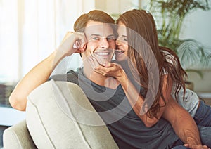 Smile, portrait and couple relaxing on sofa for bonding in living room at apartment together. Happy, resting and young