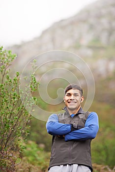 Smile, portrait and a man with arms crossed in nature for fitness, walking and exercise. Happy, morning and a male