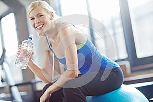 Smile, portrait or woman on ball drinking water on break in exercise, gym workout or fitness training. Tired, happy girl