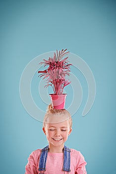 Smile, pot and child with plant in studio with positive, good and confident attitude for decoration. Funky, mockup and