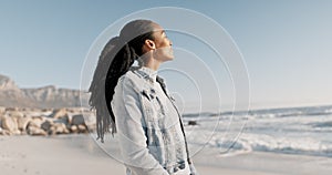 Smile, relax and black woman on beach for holiday on calm tropical island in summer with waves, blue sky and peace. View