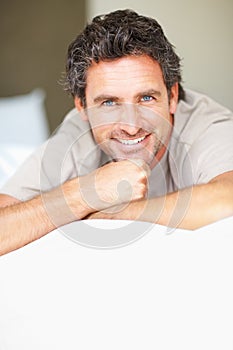 Smile, relax and portrait of mature man in bed in morning after nap, break or comfortable sleep at home. Happy, idea and