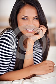 Smile, relax and portrait of woman on sofa in living room with positive, pride or confident attitude. Happy, calm and