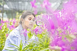 Smile Scientists hold magnifiers, happy with success. Researcher botanical research orchid wearing Scientist shirt