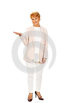 Smile senior woman holding something on open palm