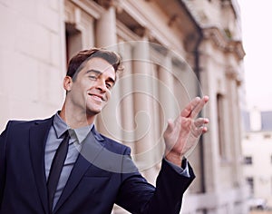 The smile after a successful work day. A handsome businessman in a suit hailing a cab outside a building.