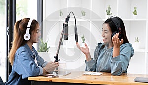 Smile two asian young woman, man radio hosts in headphones, microphone while talk, conversation, recording podcast in broadcasting