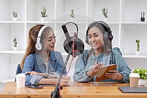 Smile two asian young woman, man radio hosts in headphones, microphone while talk, conversation, recording podcast in broadcasting