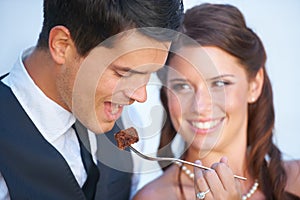 Smile, wedding and couple eating cake together for celebration of love together at party. Happy, cute and young bride