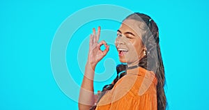 Smile, wink and okay hand gesture, woman on studio backdrop with mockup and freedom and positive opinion. Happy face of