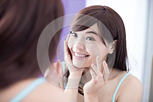 Smile woman applying moisturizer cream