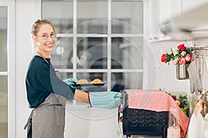 Smile woman Checking the freshly baked on oven the clock