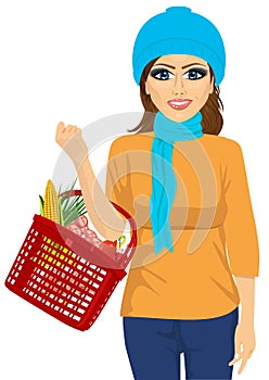 Smile woman holding a shopping basket full of food